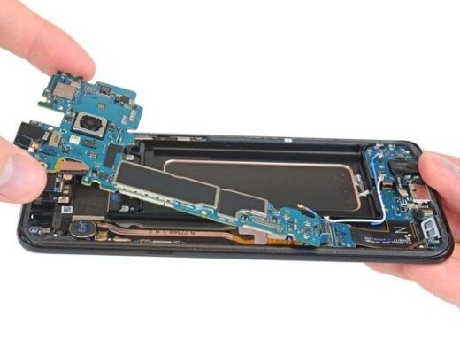 Geöffnetes Smartphone mit herausgelöster Platine und sichtbaren Bauteilen