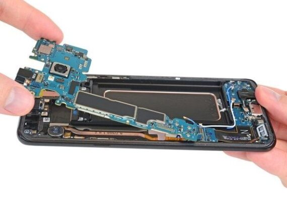 Geöffnetes Smartphone mit herausgelöster Platine und sichtbaren Bauteilen