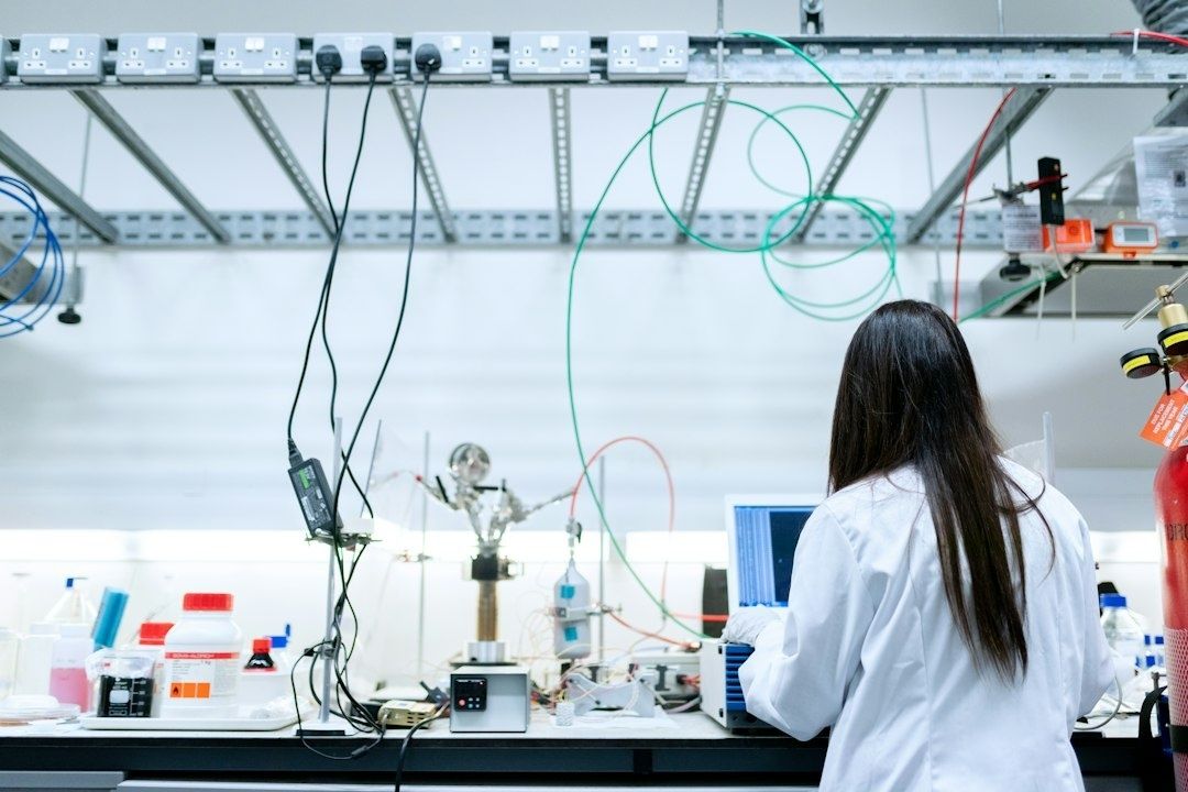 Forschende arbeitet an vernetztem Laboraufbau mit Messgeräten und Chemikalien